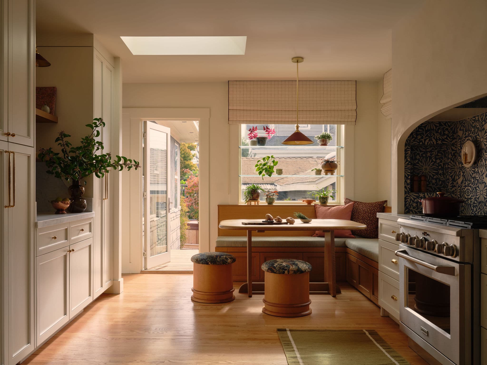 A warm, hand built kitchen with plaster walls and a tiled range alcove in Alameda, California